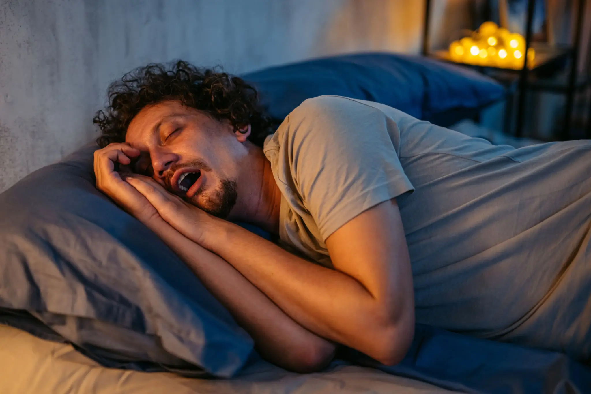 Man peacefully sleeping on a pillow at night.